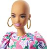 Poupée ​Barbie Fashionistas 150 chauve, vêtue d'une robe rose florale, de bottillons blancs et de boucles d'oreilles