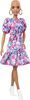 Poupée ​Barbie Fashionistas 150 chauve, vêtue d'une robe rose florale, de bottillons blancs et de boucles d'oreilles