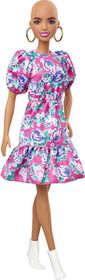 Poupée ​Barbie Fashionistas 150 chauve, vêtue d'une robe rose florale, de bottillons blancs et de boucles d'oreilles