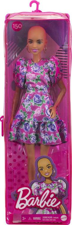 Poupée ​Barbie Fashionistas 150 chauve, vêtue d'une robe rose florale, de bottillons blancs et de boucles d'oreilles